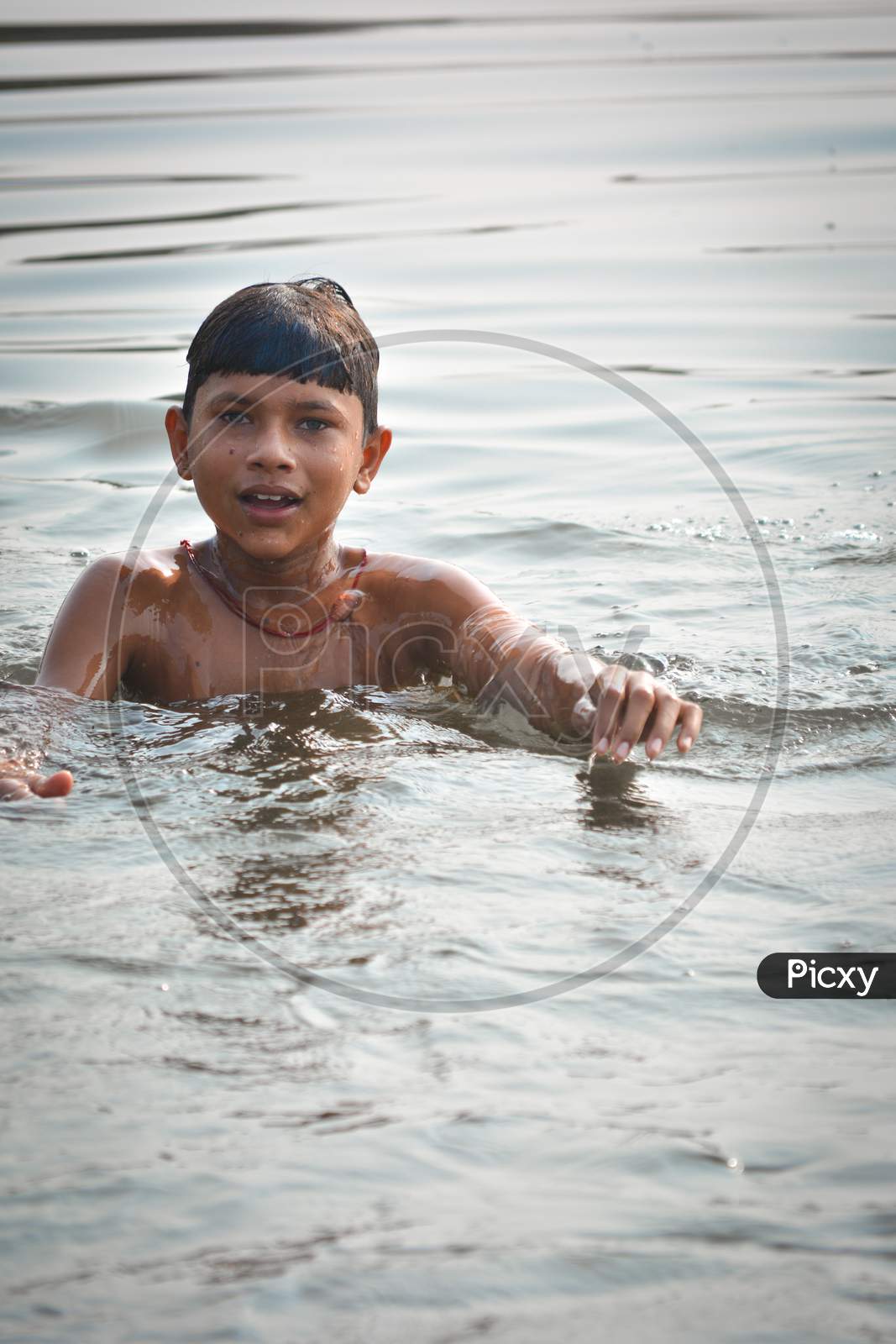 TIKAMGARH, MADHYA PRADESH, INDIA - NOVEMBER 13, 2019: Unidentified Indian village boy swimming in the fresh river water.