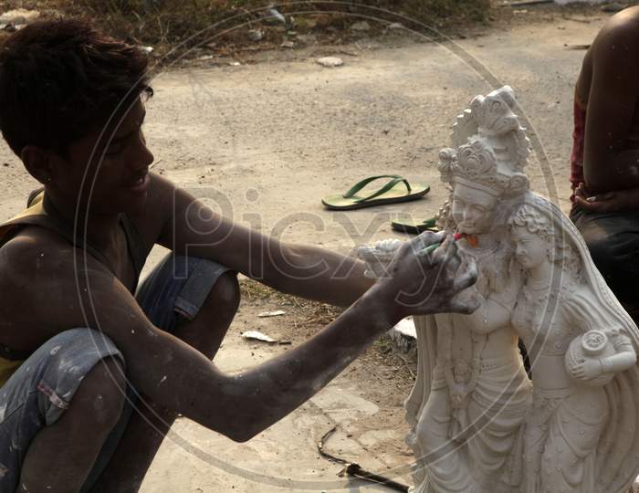 Close up shot of person making Radha Krishna Idol