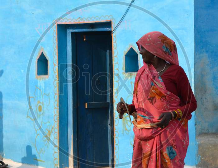 TIKAMGARH, MADHYA PRADESH, INDIA - NOVEMBER 12, 2019: Traditional indian woman in sari costume, An indian rural scene.