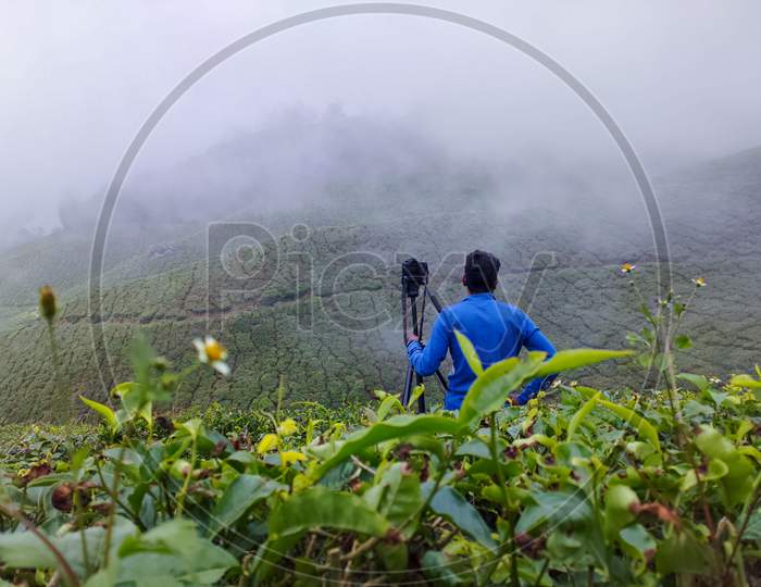 Man standing with camera in fog