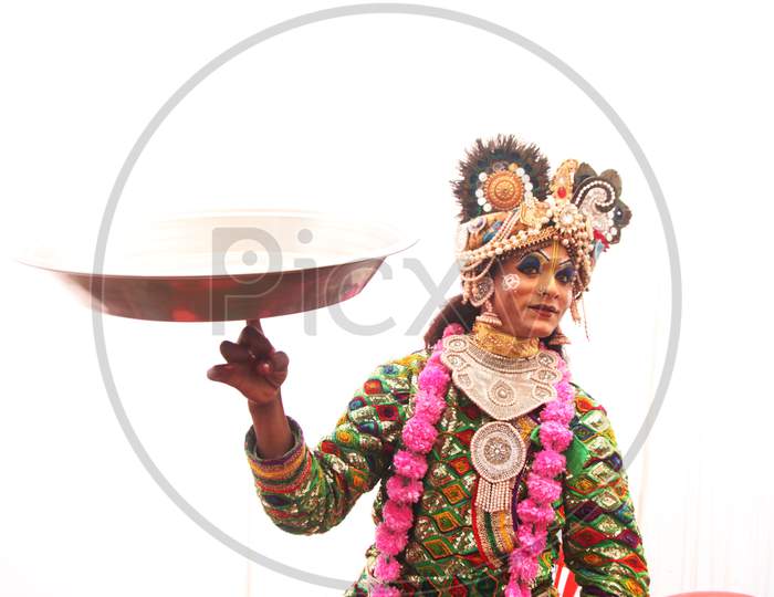A Person with Make during a Performance with a Plate on Finger