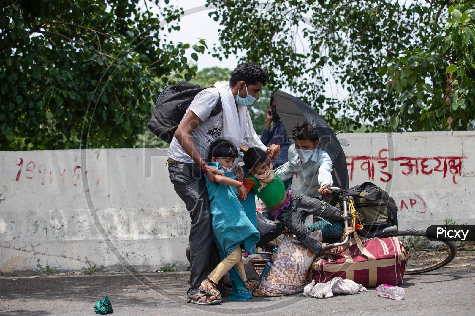 Migrant Worker Kamlesh Lost His Balance While Peddling Back To His Village In Sagar District Of Madhya Pradesh With His Children Anushka 7, And Krishna, 4, In New Delhi, India, On May 11, 2020.Distance Between New Delhi To Sagar Is Approximately 680 Kilometres.