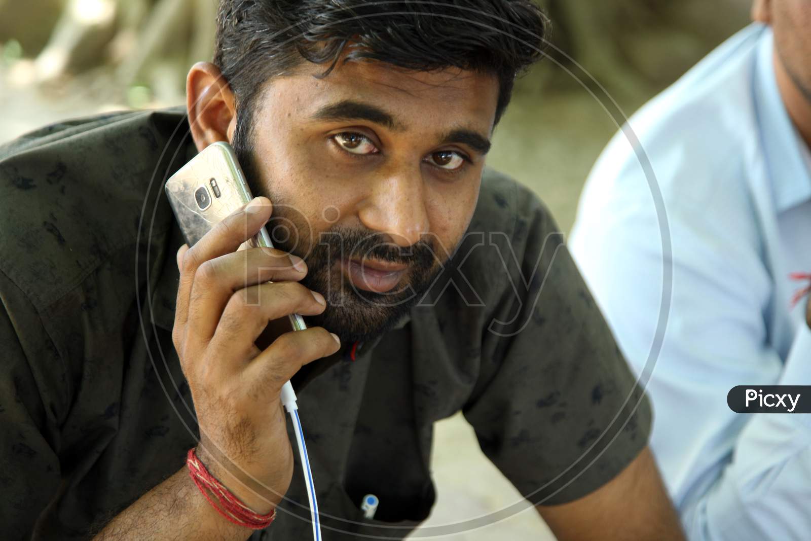 Portrait of a Young Indian Man using a Mobile