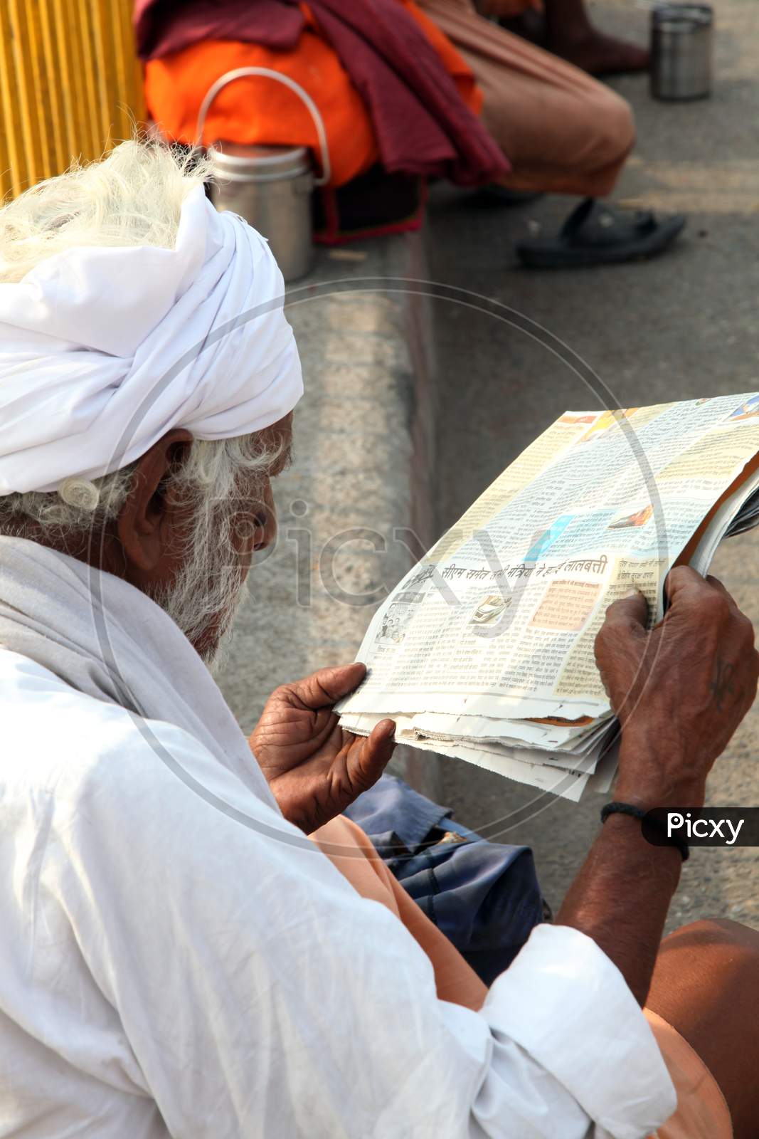 Portrait of an Old Indian Hindu Sadhu or Baba reading Newspaper
