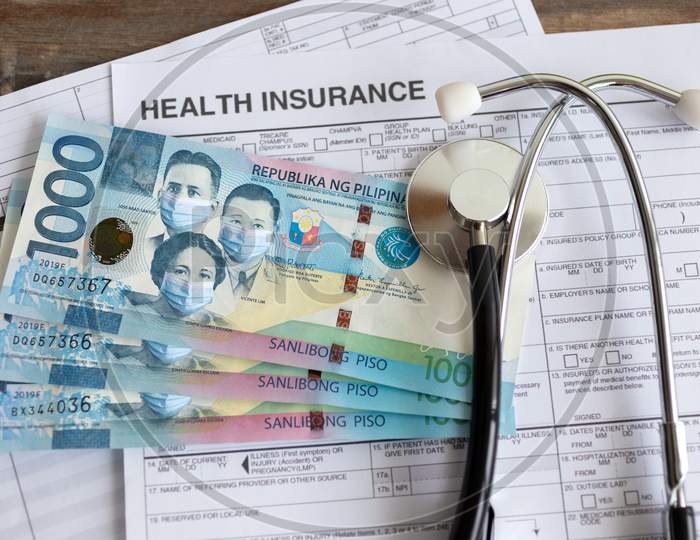 One thousand Philippines peso with face mask on insurance paper bill. Health care cost during coronavirus covid outbreak concept
