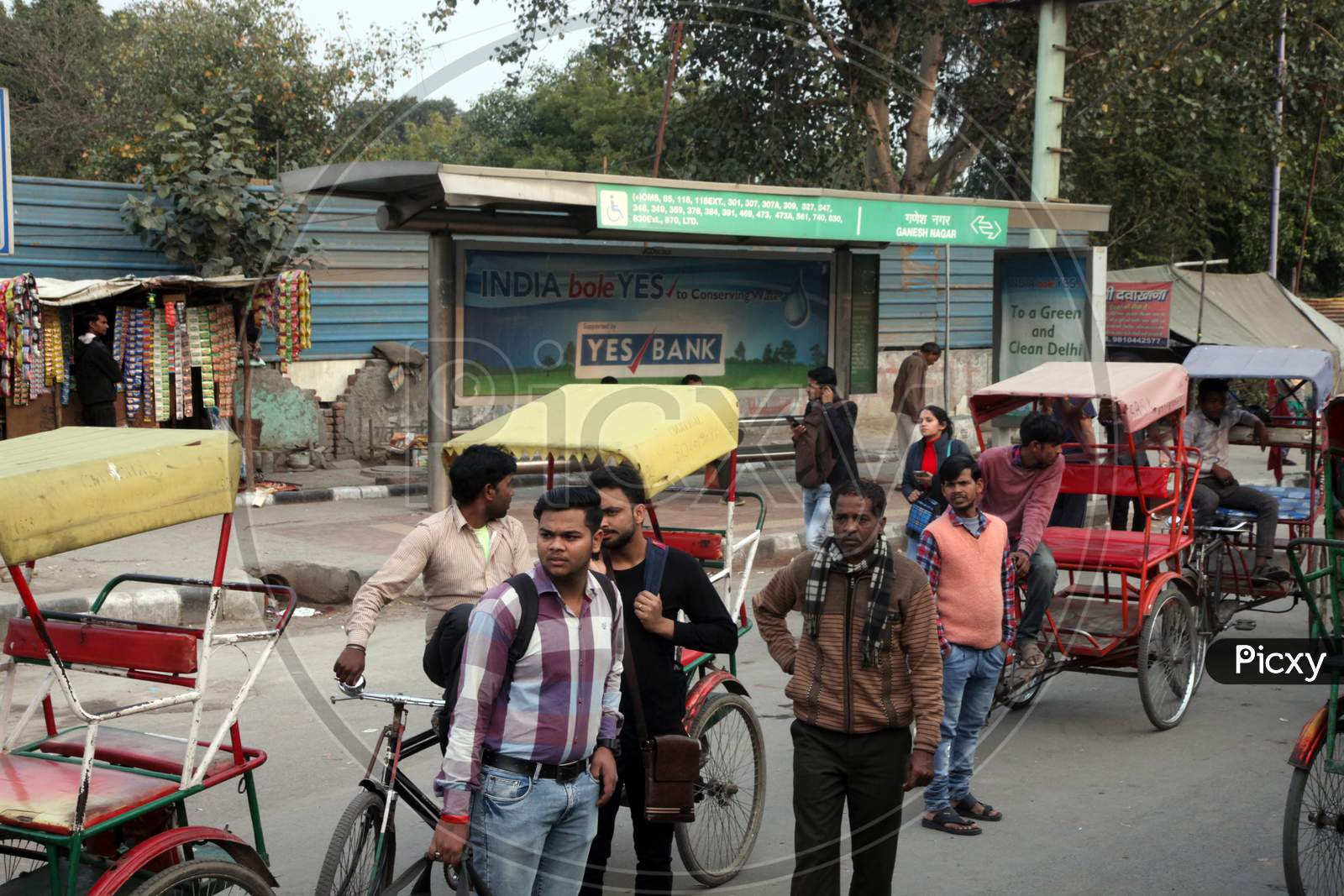 People with Rickshaws on a Single Lane Road