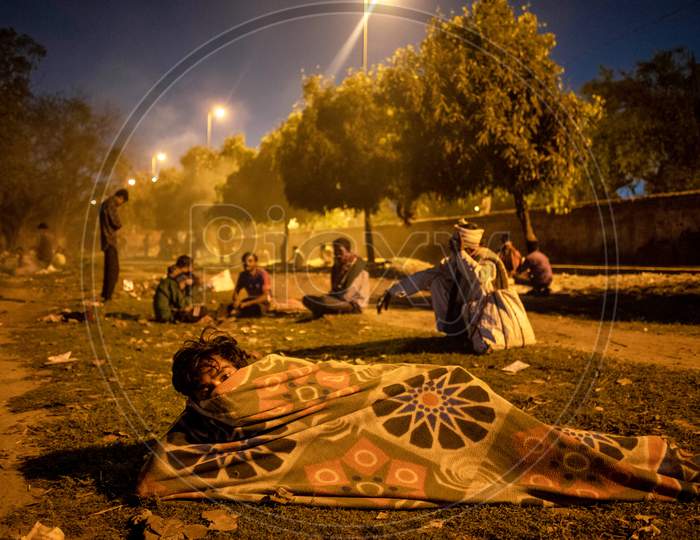 A Homeless Man Wears A Protective Facemask As He Lies Along The Bank Of River Yamuna During A Government Imposed Nationwide Lockdown As A Preventive Measure Against The Covid-19 Corona Virus In New Delhi, India, On April 9, 2020.