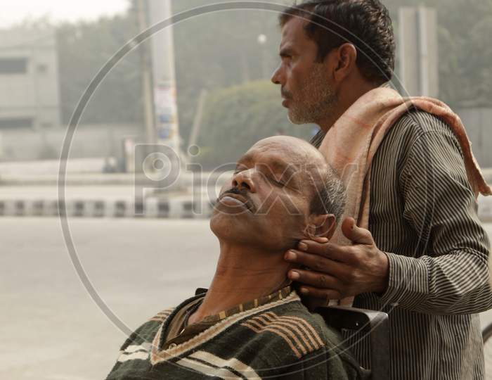 An Indian street barber giving his client a head massage