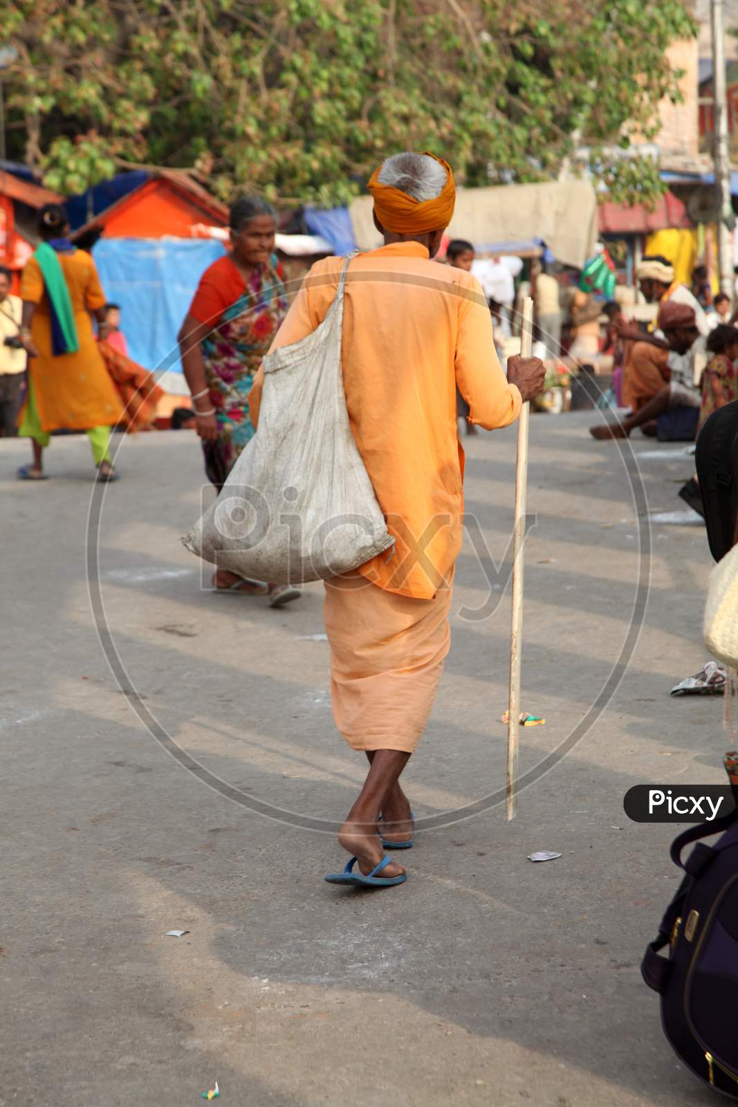 An Old Indian Hindu Sadhu or Baba walking on the Road