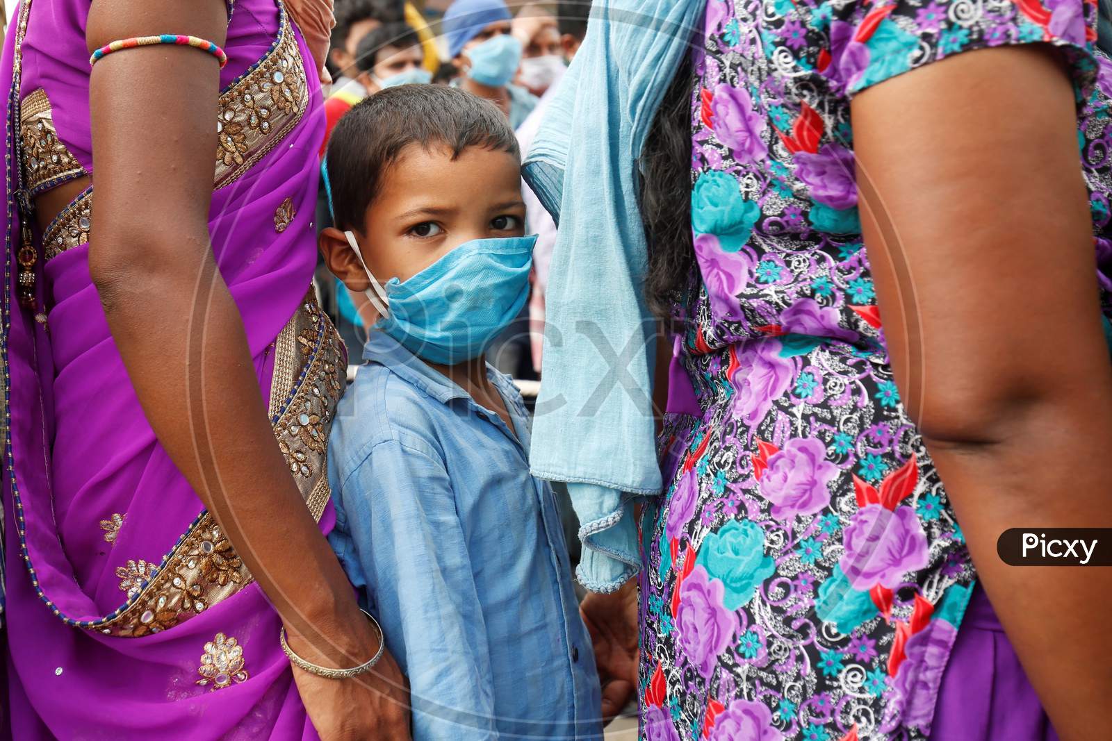 A boy waits for a health screening before boarding a bus to be taken to a government-arranged train to his destination after the state eased lockdown regulations during the extended nationwide lockdown to prevent the spread of coronavirus (Covid-19) in Bangalore, India.