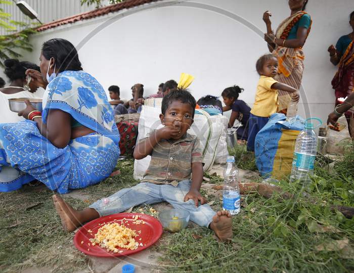 The child of a migrant workers eats his lunch on a pavement before boarding a bus to be taken to a government-arranged train to his destination after the state eased lockdown regulations during the extended nationwide lockdown to prevent the spread of coronavirus (Covid-19) in Bangalore, India.