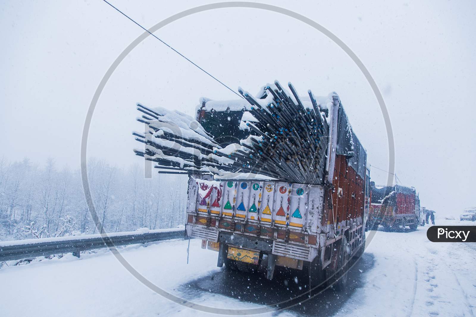 Truck With Loaded Iron Rods On Dangerous Snowy Road,High Way. Mowing In Winter Season, Bad Weather And Transportation Concept - Image