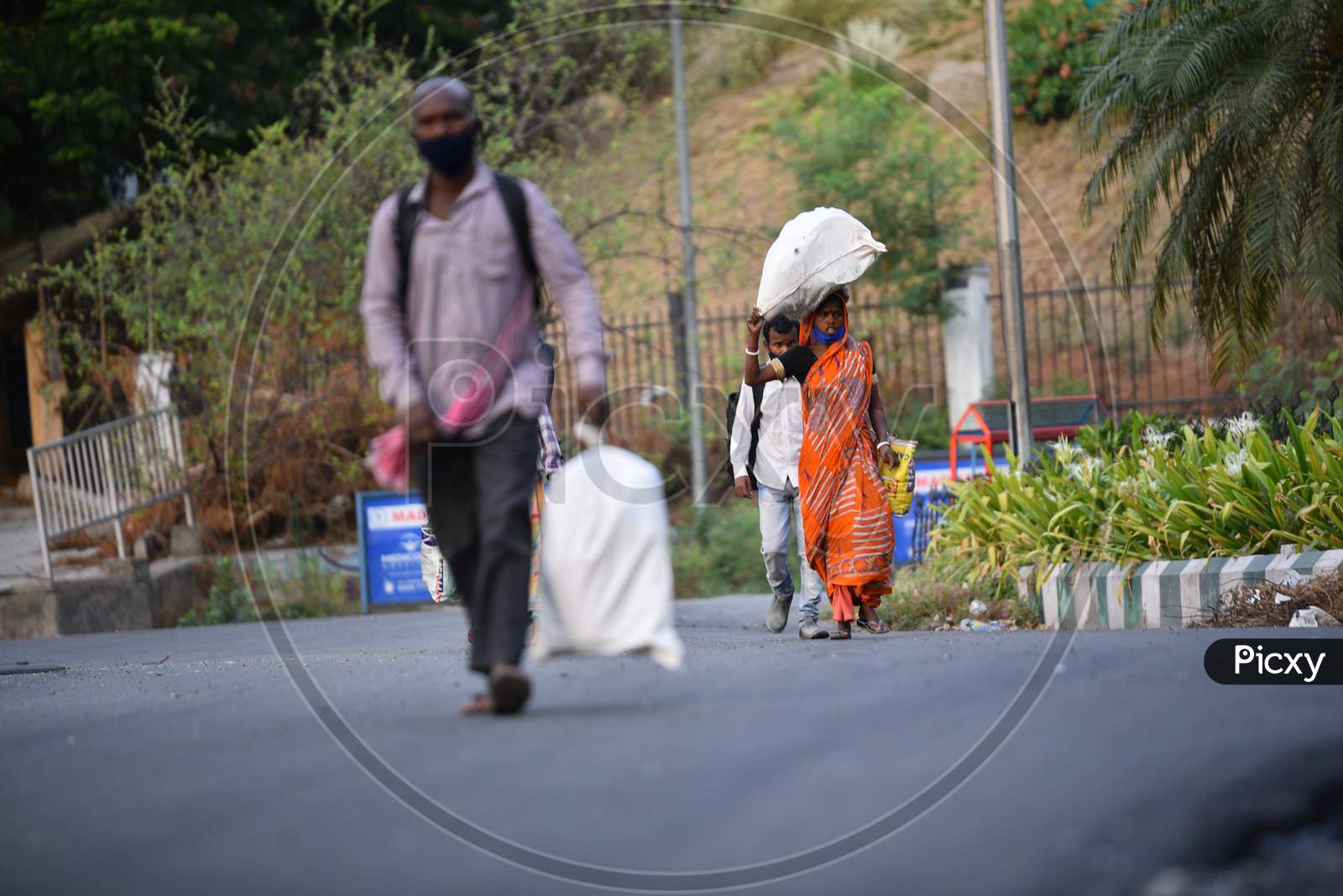Migrant Workers walk with their luggage to a nearby registration centre in a bid to board Shramik Special Trains, Hitech City,Hyderabad, May 22,2020