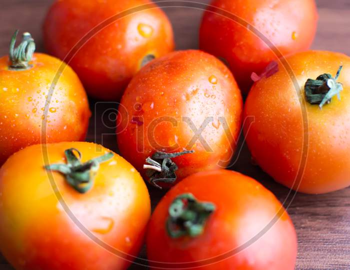 Tomatoes placed together on a wooden floor
