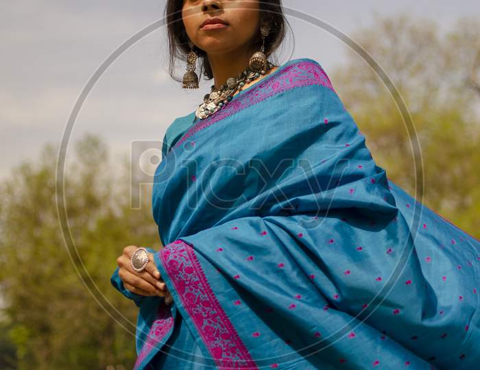 Girl In Blue Saree Standing With A Smile On Her Face