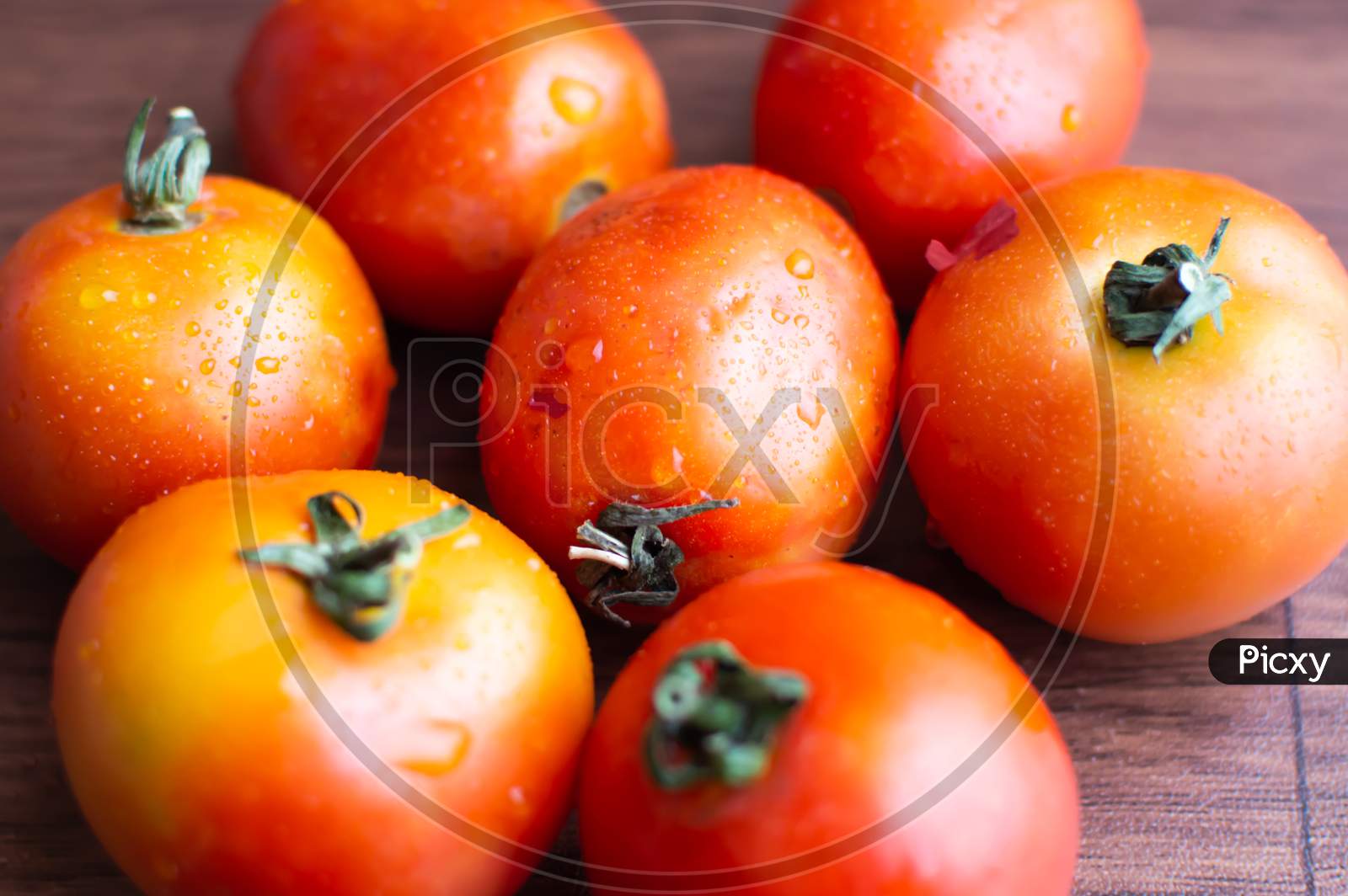 Tomatoes placed together on a wooden floor
