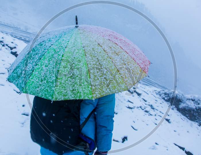 White Landscape And Thick Snow In Winter Looking Frosty And Cold,A Person Standing With Colorful Rainbow Umbrella, Snow Falling, Bad Weather, Background - Image