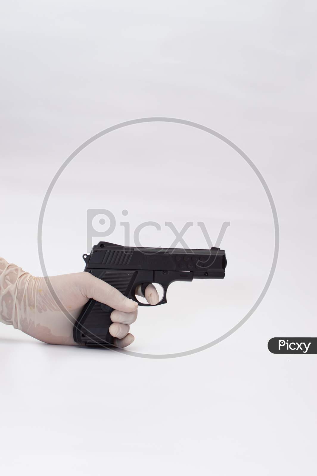 black gun in a hand wearing glove