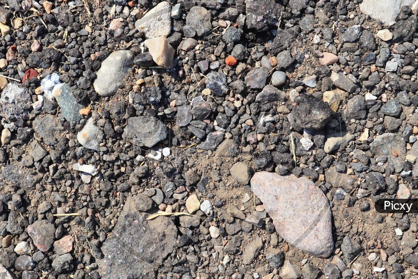 Detailed close up view on pebbles and stones on a gravel ground texture in high resolution