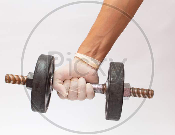 Dumbbell in a hand wearing gloves