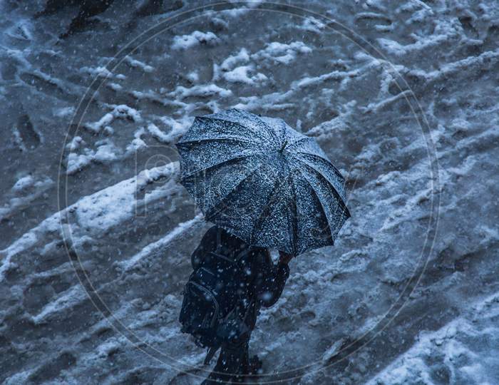Winter Snow Falling, A Person Walking With Black Umbrella On The Road, Top Angle, Background - Image