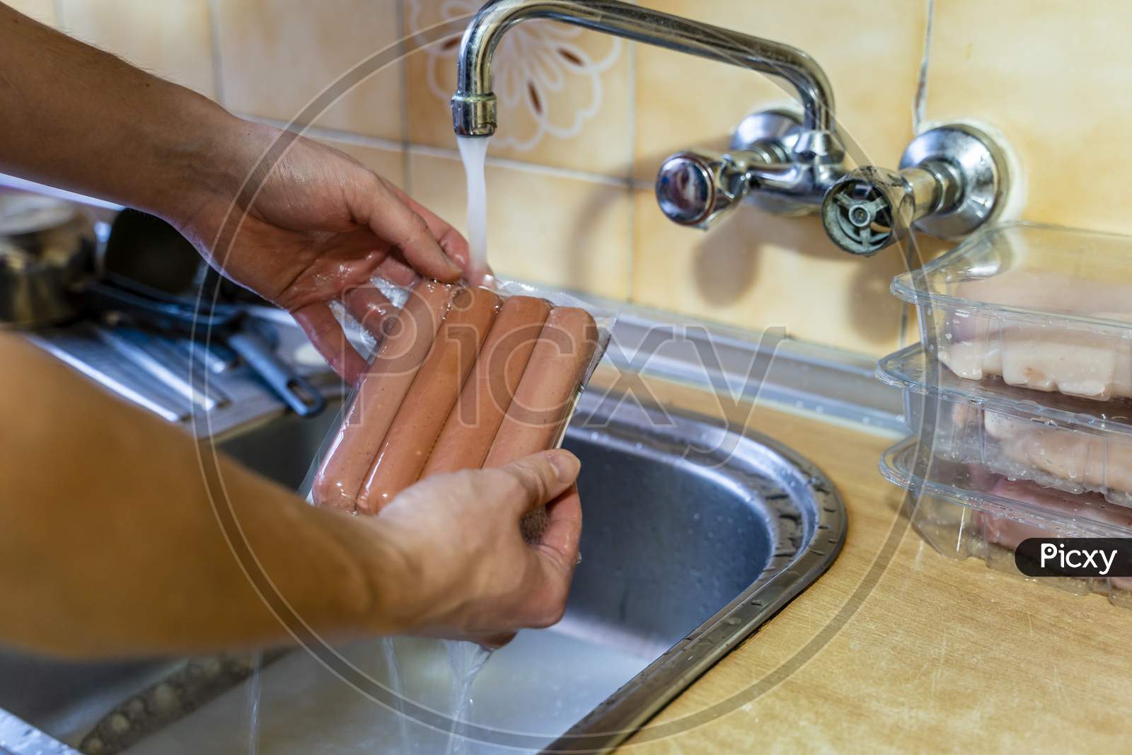 Washing Groceries, Sausages In Plastic Package