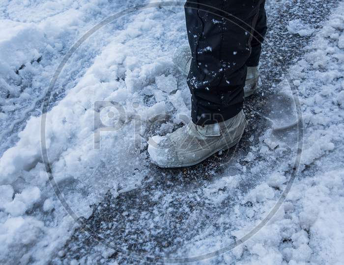 Man Standing On Fresh Snow, Close-Up Of Leg Covered By Snow, Winter Concept - Image