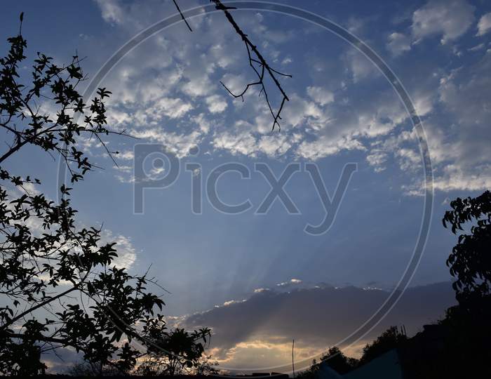 Summer Landscape With Tress, Sunset And Dramatic Clouds Over The Blue Sky