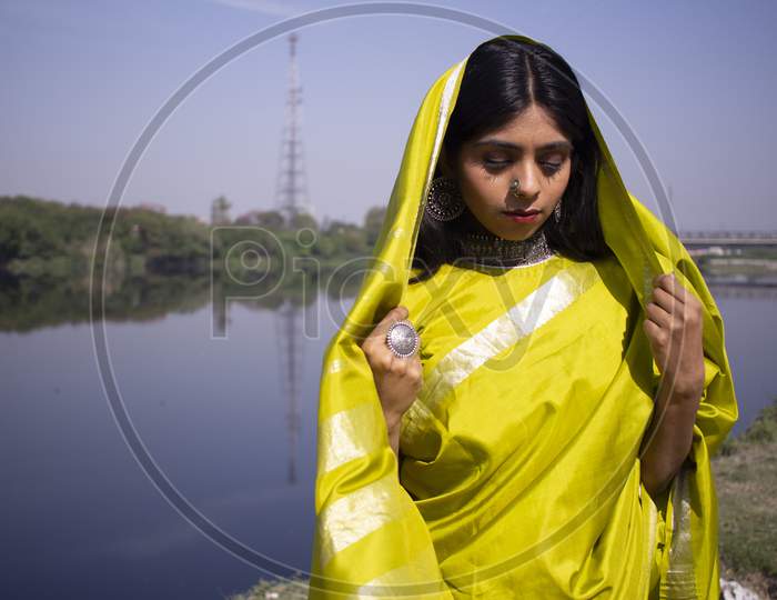 Indian Girl Wearing Green Saree Standing In A Landscape