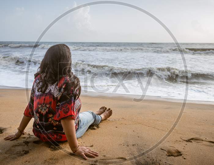 Girl Soaking Up The Natural Sea View And Fresh Breeze On The Coast