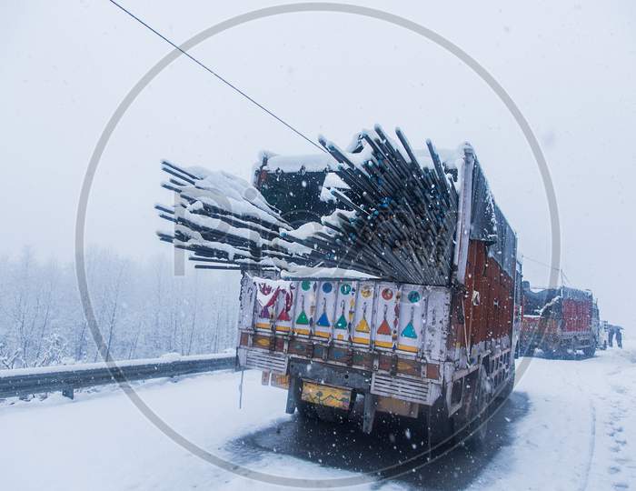 Truck With Loaded Iron Rods On Dangerous Snowy Road,High Way. Mowing In Winter Season, Bad Weather And Transportation Concept - Image