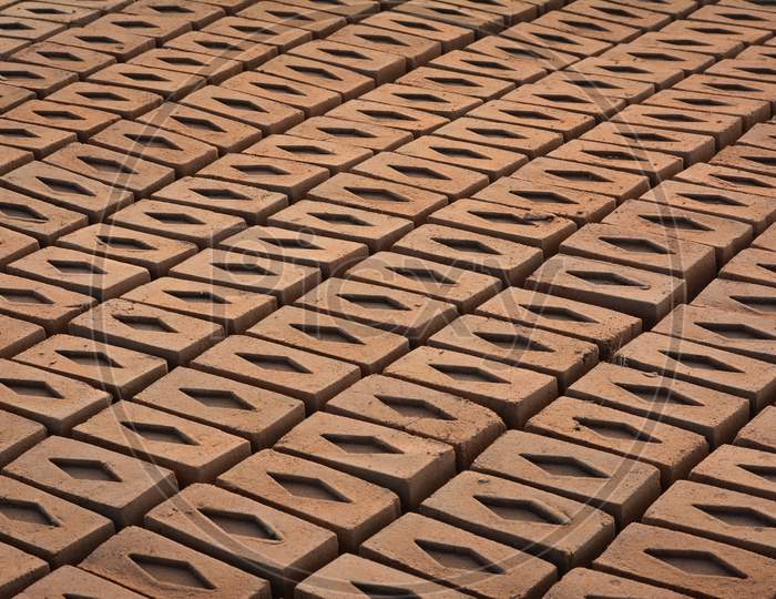 Raw brick laid out in stacks for drying. Bricks in a brick factory. Traditional production of clay bricks in India.