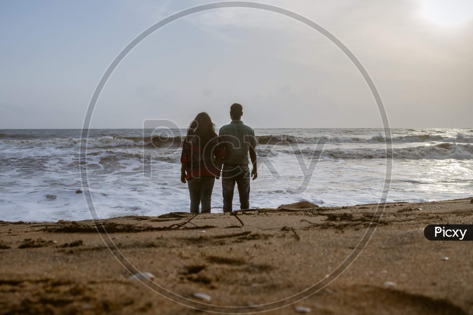 Couple Holding Each Others Hand And Soaking Up The Natural Sea View