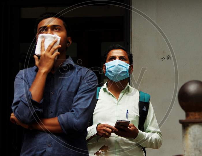 Men look at a screen (not pictured) displaying the Sensex results following the coronavirus outbreak, on the facade of the Bombay Stock Exchange (BSE) building in Mumbai, India on March 12, 2020.