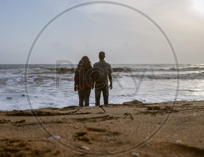 Couple Holding Each Others Hand And Soaking Up The Natural Sea View