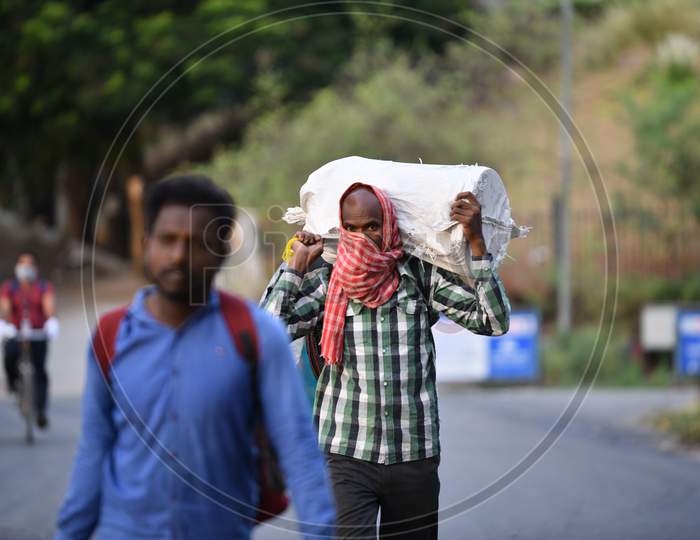 Migrant Workers walk with their luggage to a nearby registration centre in a bid to board Shramik Special Trains, Hitech City,Hyderabad, May 22,2020