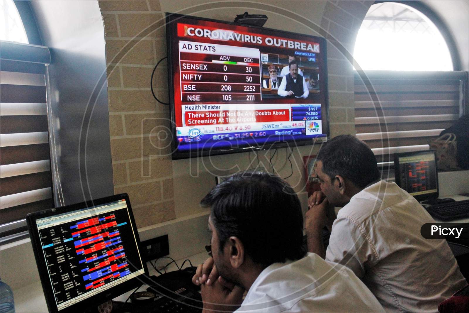 Brokers work at their computer terminal at a stock brokerage firm following the coronavirus outbreak, in Mumbai, India on March 12, 2020.