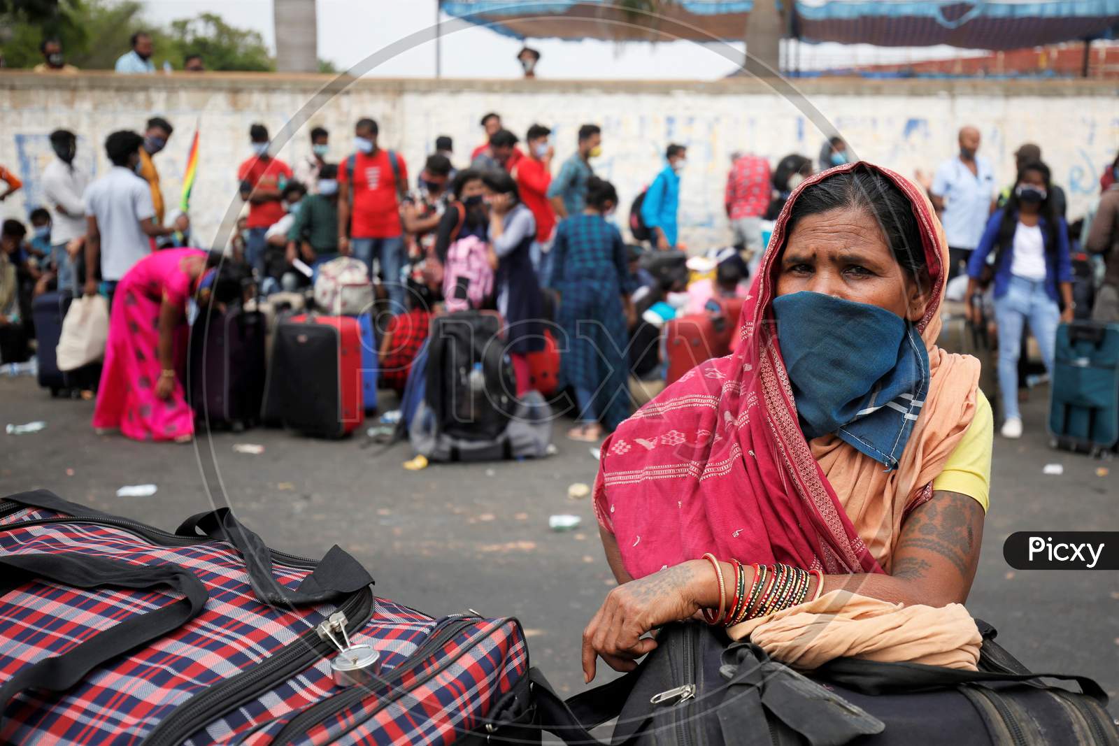 A woman waits for a health screening before boarding a bus to be taken to a government-arranged train to her destination after the state eased lockdown regulations during the extended nationwide lockdown to prevent the spread of coronavirus (Covid-19) in Bangalore, India.