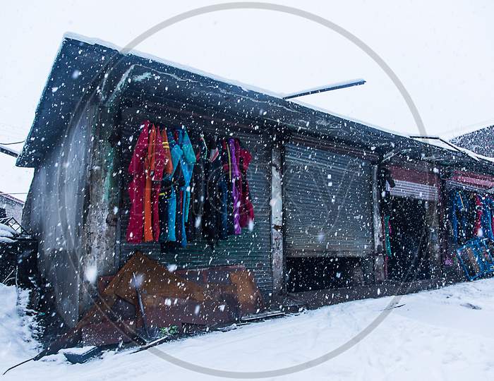 Woolen Winter Clothes Hanging Outside The Old Shop In Snowy Day, Heavy Snowfall - Image