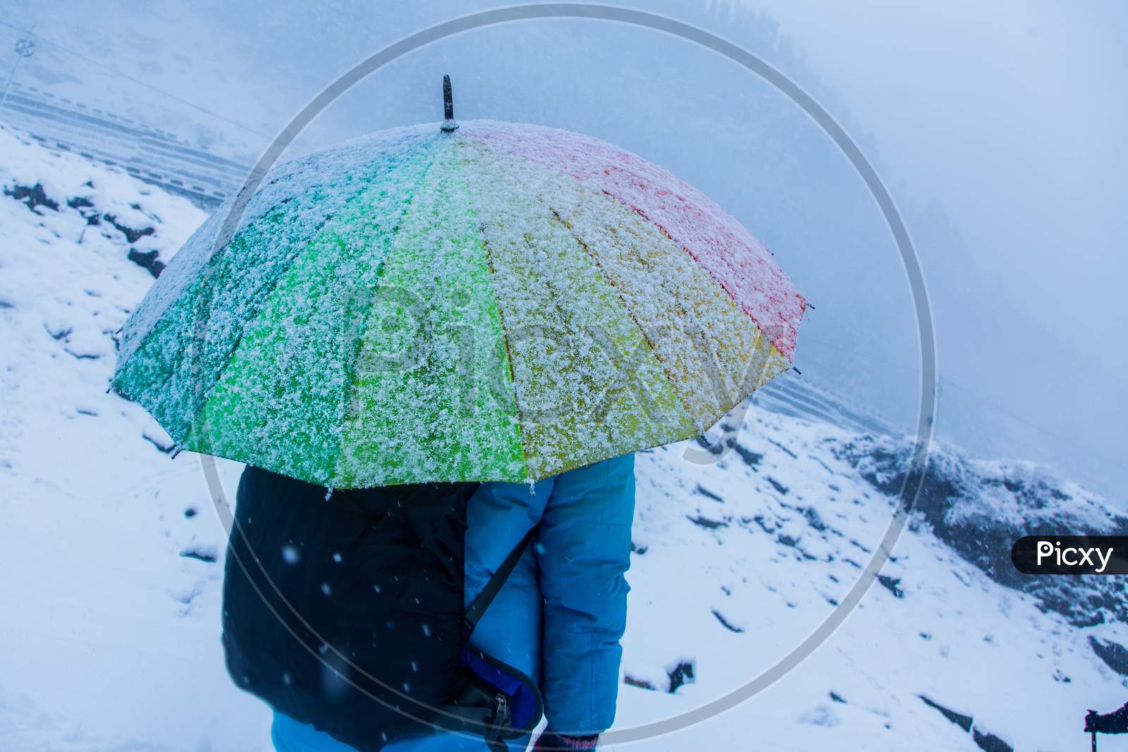 White Landscape And Thick Snow In Winter Looking Frosty And Cold,A Person Standing With Colorful Rainbow Umbrella, Snow Falling, Bad Weather, Background - Image