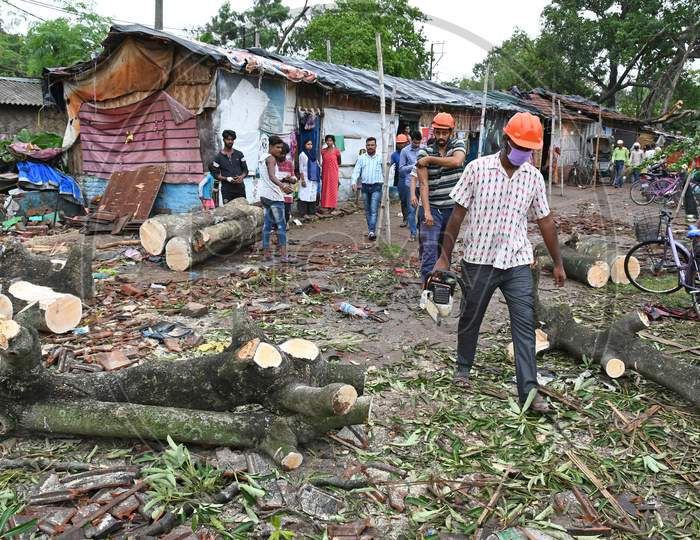The civil defence officials trying to remove branches of trees fallen heavily crushing three residential houses during Cyclone Amphan in Burdwan town.