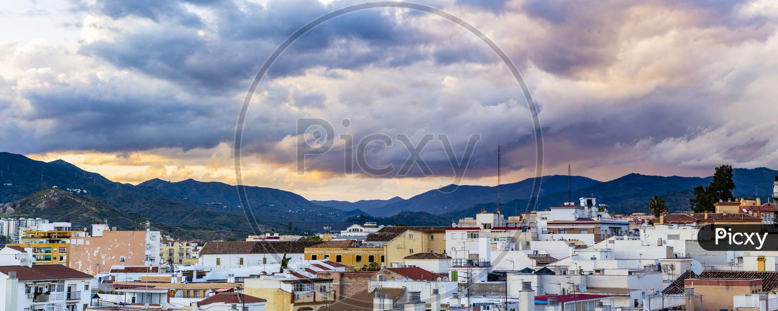 Panoramic View Urban District, With Sunset And Mountains In Background