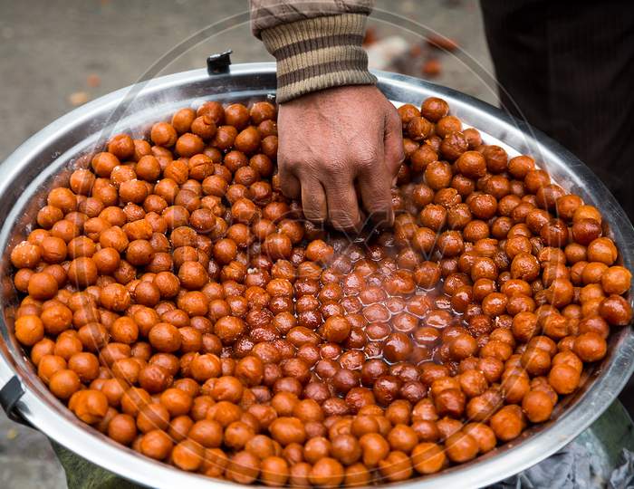 Man Picking Delicious Indian Sweet, Gulabjamun, Tasty Sweet Balls, Street Food, Dessert, Asian Cuisine Concept. - Image