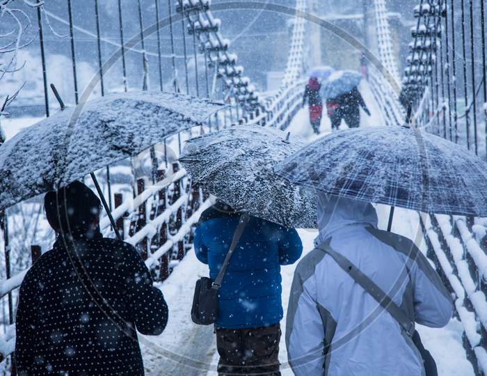 Heavy Winter Snow Fall, People Walking With Umbrellas On The Bridge,Bad Weather - Image