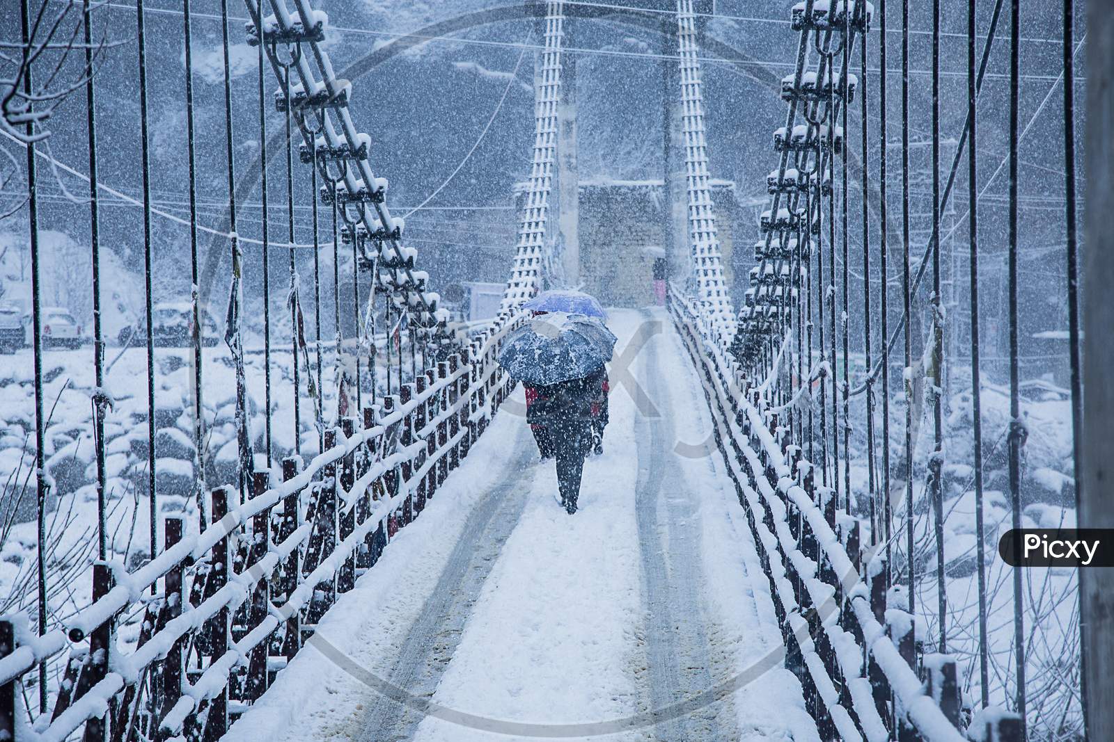 Heavy Winter Snow Fall, A Person Walking Alone With Black Umbrella On The Bridge, Wide Angle Shot - Image
