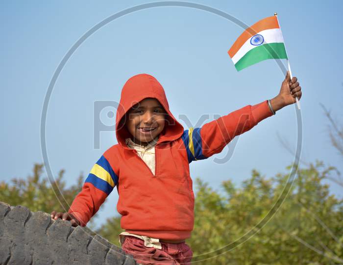 TIKAMGARH, MADHYA PRADESH, INDIA - JANUARY 22, 2020: Unidentified indian village little boy holding indian flag.