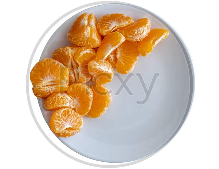 Top Down View Of Pealed Mandarin Peaces On White Plate On White Background