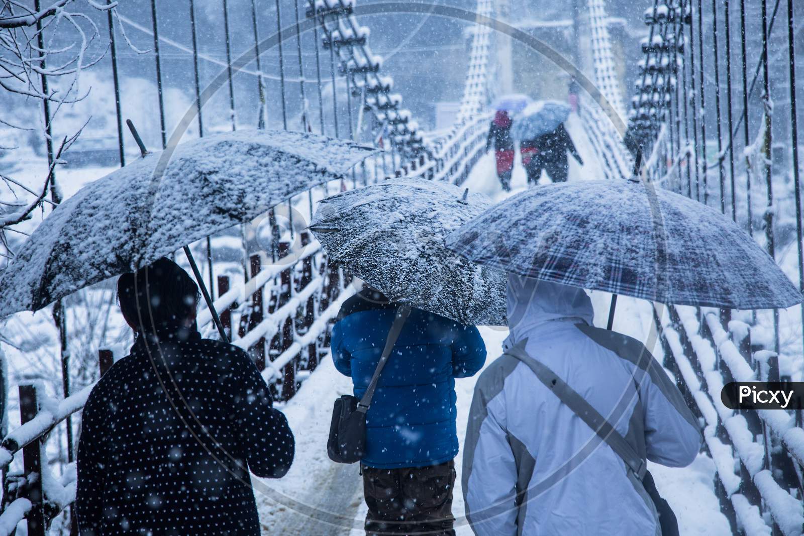 Heavy Winter Snow Fall, People Walking With Umbrellas On The Bridge,Bad Weather - Image