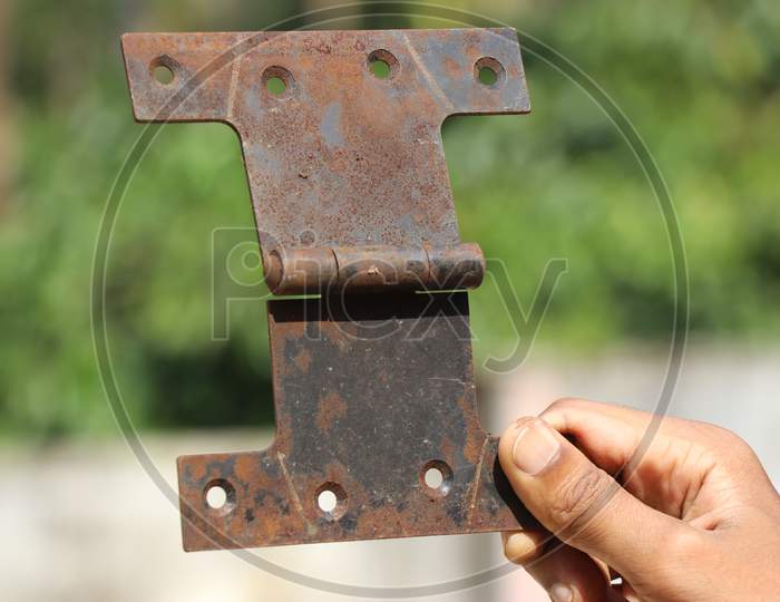 Door Hinge Used To Support Door To The Frame Held In Hand Which Looks Rusty