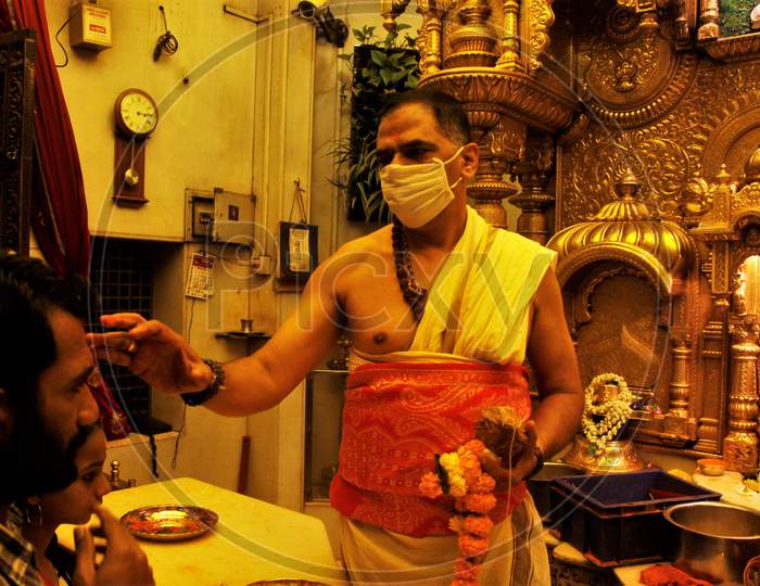 A Hindu priest wearing a protective mask is seen inside a temple in Mumbai, India, March 13, 2020.